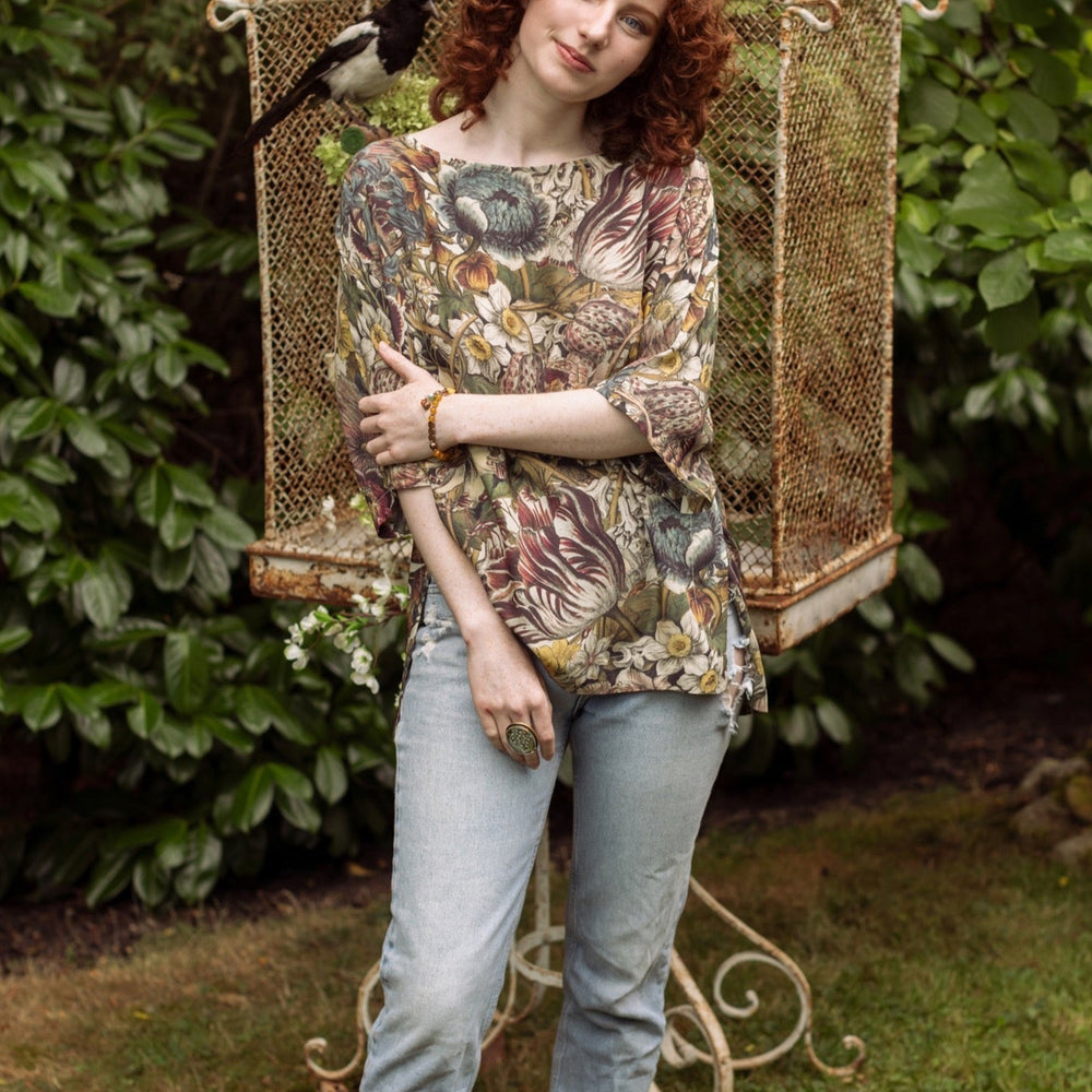 
                  
                    Model wearing the Love Grows Wild Luxe Tee featuring lush floral etchings inspired by 1700s botanical art with hidden bee trim detail – Market of Stars.
                  
                