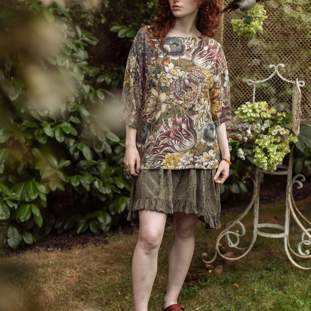 
                  
                    Model wearing the Love Grows Wild Luxe Tee featuring lush floral etchings inspired by 1700s botanical art with hidden bee trim detail – Market of Stars.
                  
                