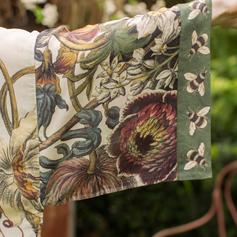 
                  
                    Model wearing kimono featuring 1700s March floral etchings and charming bumblebee trim inspired by vintage seed catalogues – Market of Stars.
                  
                