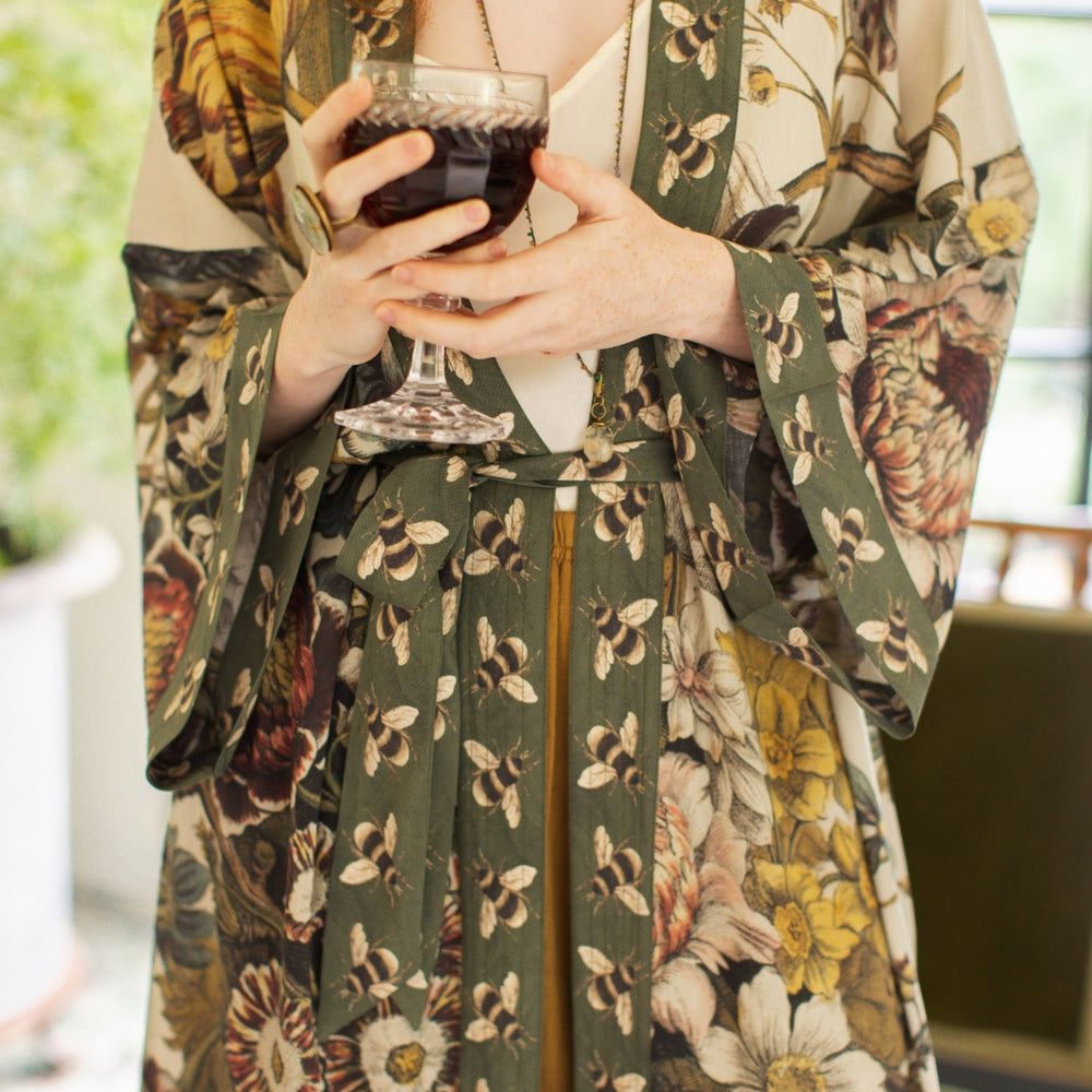 
                  
                    Model wearing kimono featuring 1700s March floral etchings and charming bumblebee trim inspired by vintage seed catalogues – Market of Stars.
                  
                