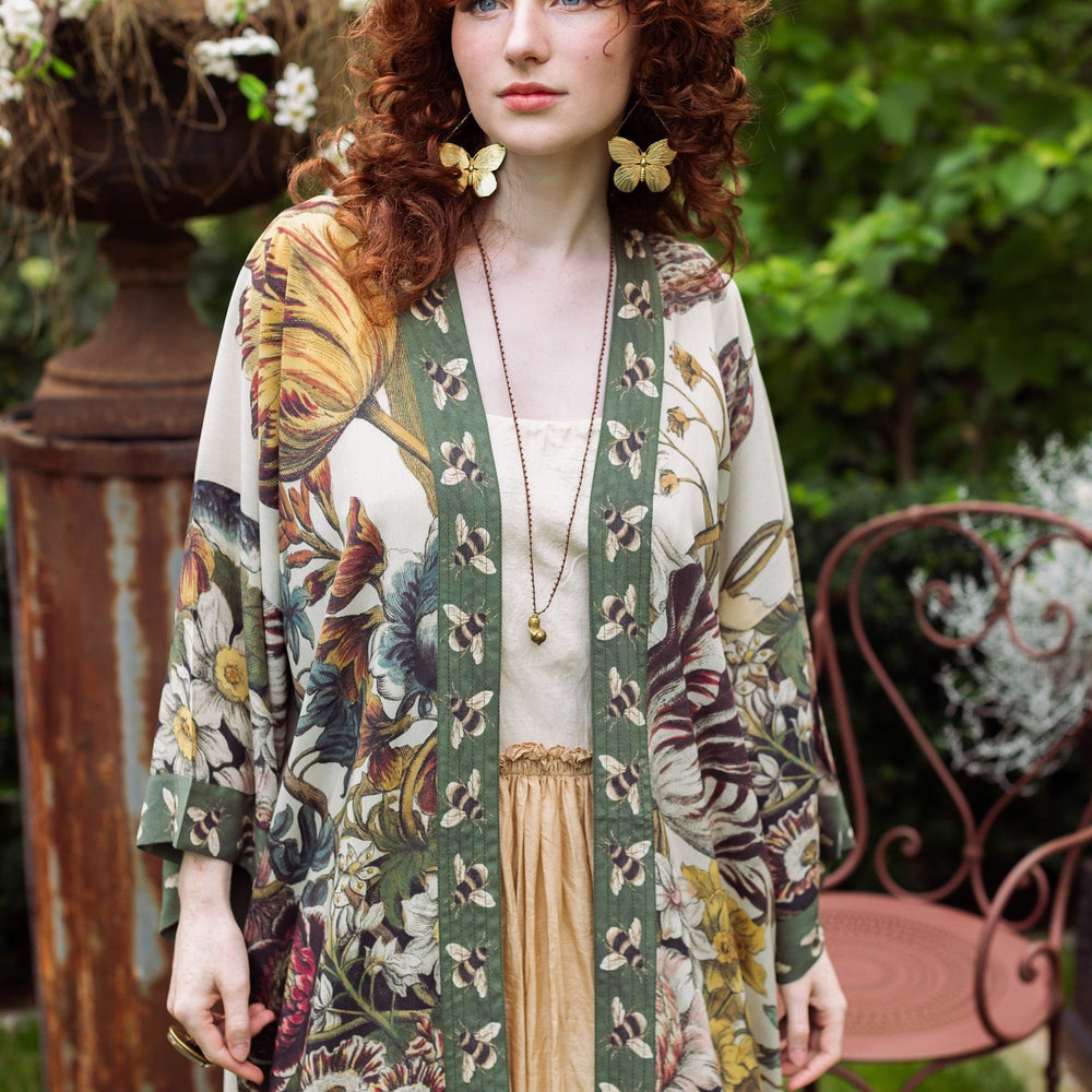 
                  
                    Model wearing kimono featuring 1700s March floral etchings and charming bumblebee trim inspired by vintage seed catalogues – Market of Stars.
                  
                