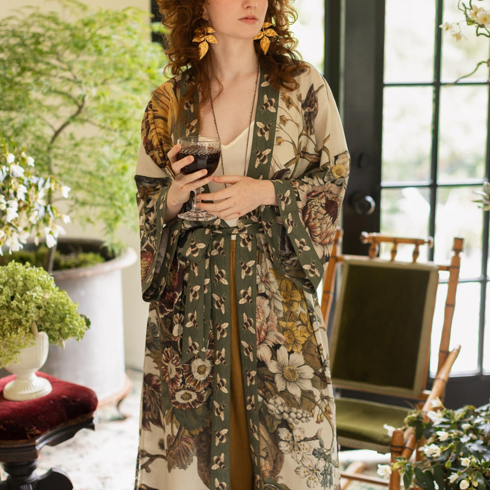 
                  
                    Model wearing kimono featuring 1700s March floral etchings and charming bumblebee trim inspired by vintage seed catalogues – Market of Stars.
                  
                