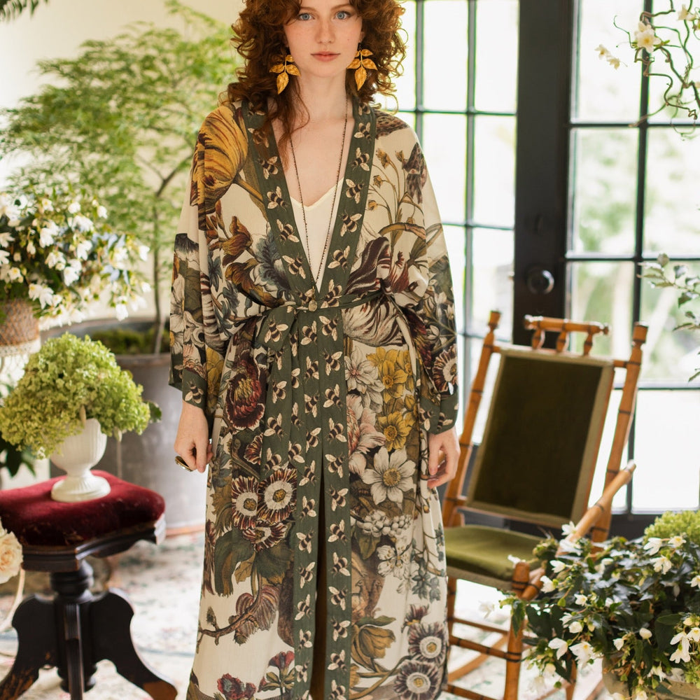 
                  
                    Model wearing kimono featuring 1700s March floral etchings and charming bumblebee trim inspired by vintage seed catalogues – Market of Stars.
                  
                