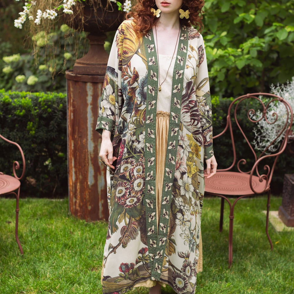 
                  
                    Model wearing kimono featuring 1700s March floral etchings and charming bumblebee trim inspired by vintage seed catalogues – Market of Stars.
                  
                