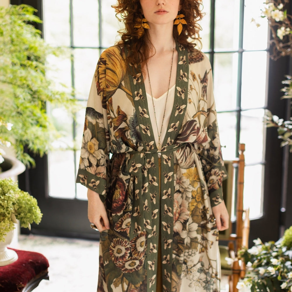 
                  
                    Model wearing kimono featuring 1700s March floral etchings and charming bumblebee trim inspired by vintage seed catalogues – Market of Stars.
                  
                
