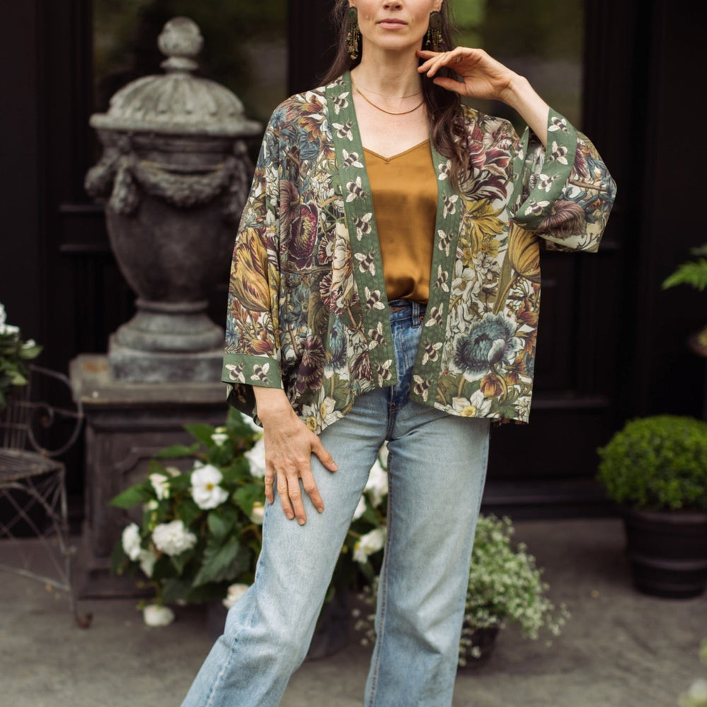 
                  
                    Model wearing Love Grows Wild Pixie Duster featuring hand-coloured 1700s floral etchings and charming bumblebee trim, celebrating the joy of abundance – Market of Stars.
                  
                