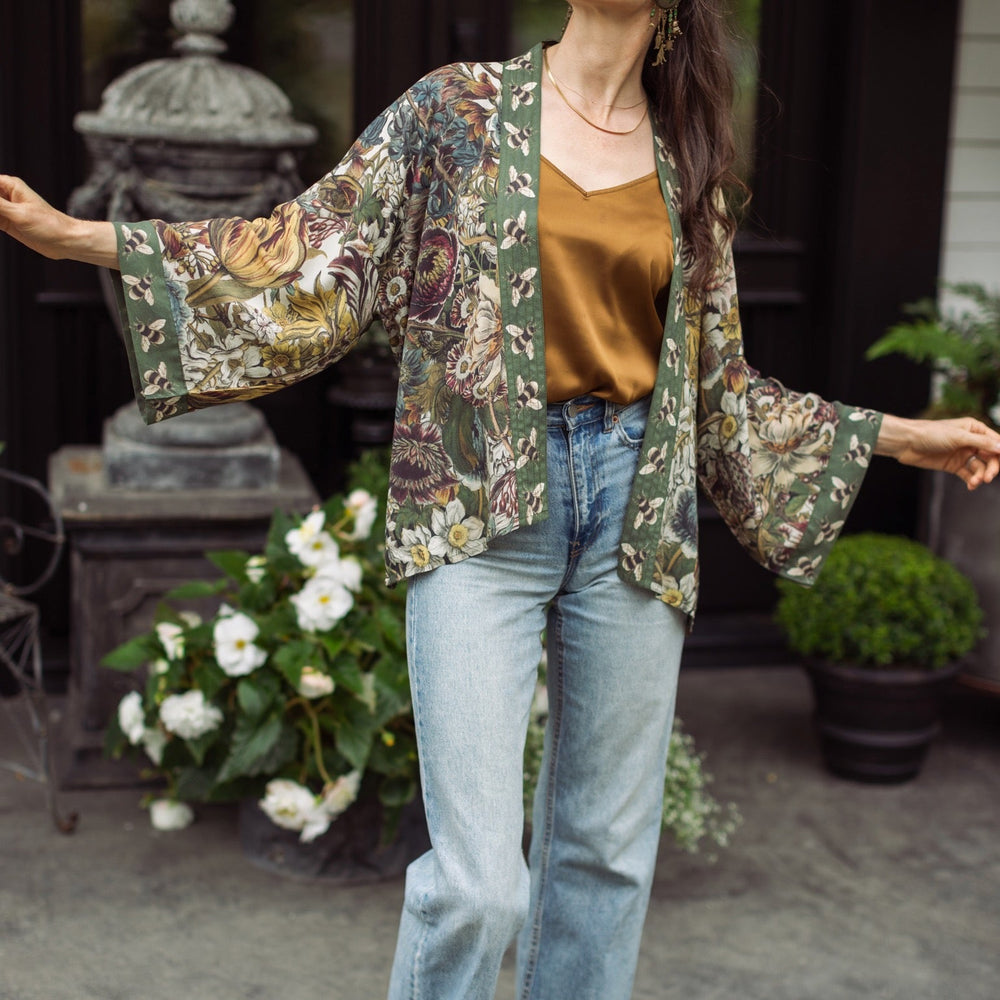 
                  
                    Model wearing Love Grows Wild Pixie Duster featuring hand-coloured 1700s floral etchings and charming bumblebee trim, celebrating the joy of abundance – Market of Stars.
                  
                