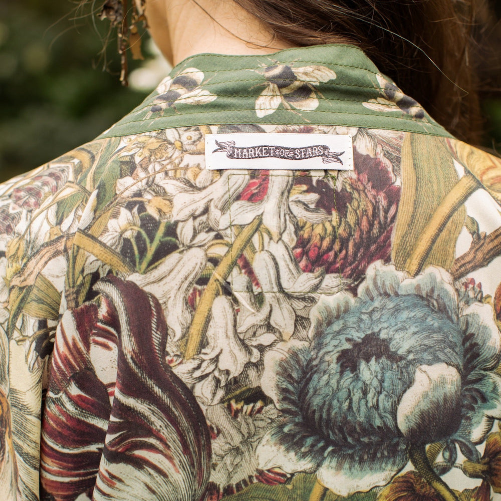 
                  
                    Model wearing Love Grows Wild Pixie Duster featuring hand-coloured 1700s floral etchings and charming bumblebee trim, celebrating the joy of abundance – Market of Stars.
                  
                