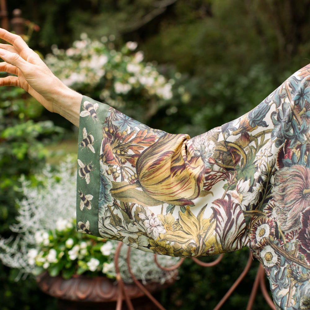 
                  
                    Model wearing Love Grows Wild Pixie Duster featuring hand-coloured 1700s floral etchings and charming bumblebee trim, celebrating the joy of abundance – Market of Stars.
                  
                