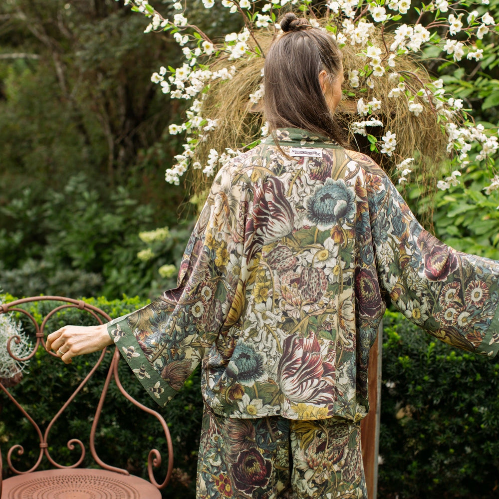 
                  
                    Model wearing Love Grows Wild Pixie Duster featuring hand-coloured 1700s floral etchings and charming bumblebee trim, celebrating the joy of abundance – Market of Stars.
                  
                