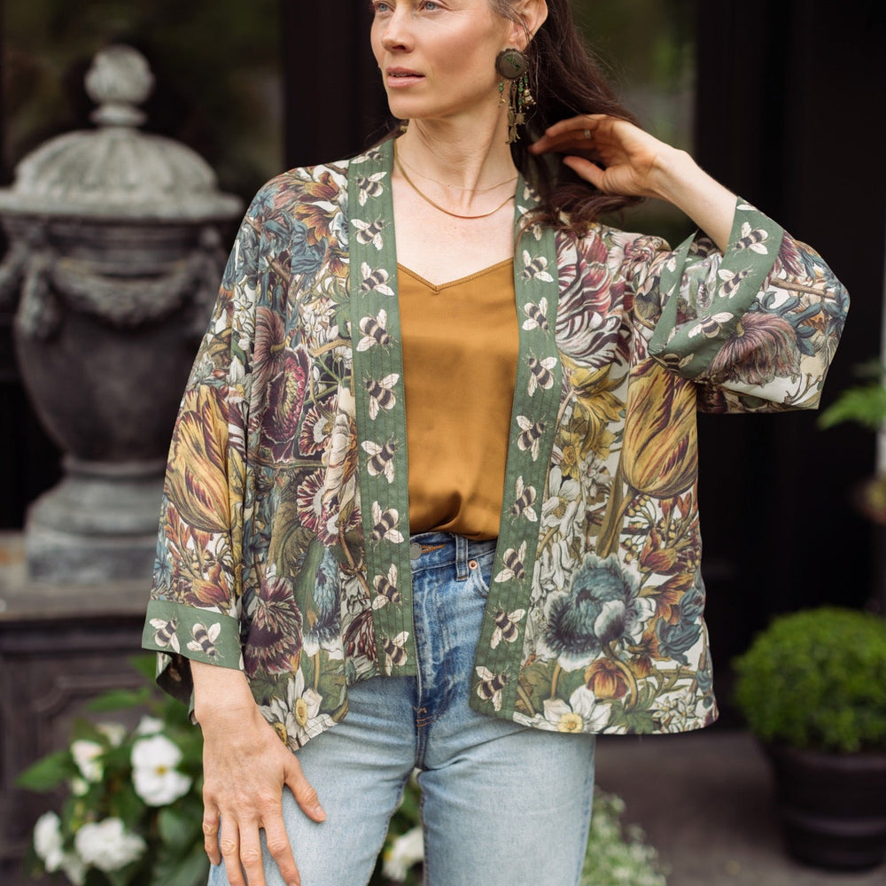 
                  
                    Model wearing Love Grows Wild Pixie Duster featuring hand-coloured 1700s floral etchings and charming bumblebee trim, celebrating the joy of abundance – Market of Stars.
                  
                