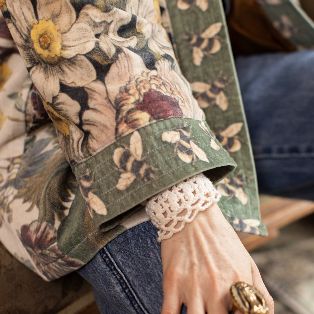 
                  
                    Model wearing a soft cotton velvet duster featuring lush 1700s botanical blooms and bumblebee trim - Market of Stars
                  
                