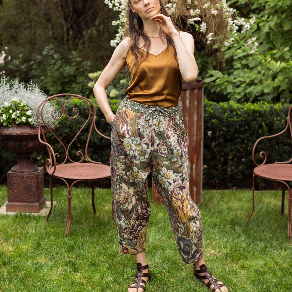 
                  
                    Model styled in Love Grows Wild Artist Pants featuring 1700s hand-coloured floral etchings and bumblebee trim – relaxed lantern hem and cropped fit – Market of Stars
                  
                