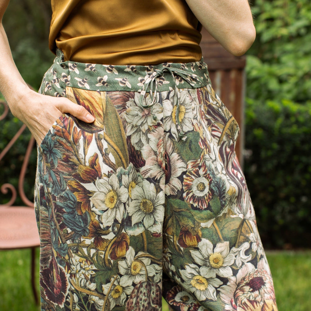 
                  
                    Model styled in Love Grows Wild Artist Pants featuring 1700s hand-coloured floral etchings and bumblebee trim – relaxed lantern hem and cropped fit – Market of Stars
                  
                