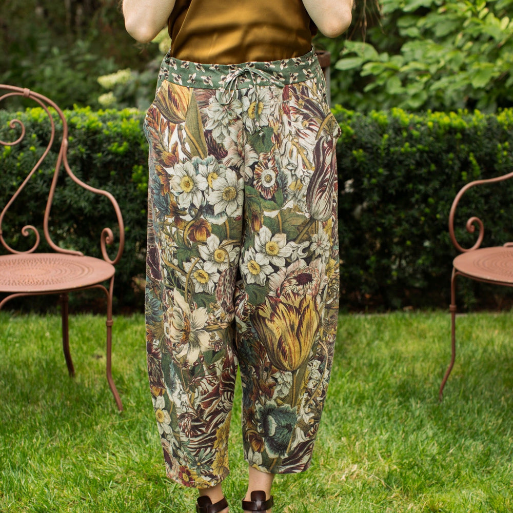 
                  
                    Model styled in Love Grows Wild Artist Pants featuring 1700s hand-coloured floral etchings and bumblebee trim – relaxed lantern hem and cropped fit – Market of Stars
                  
                