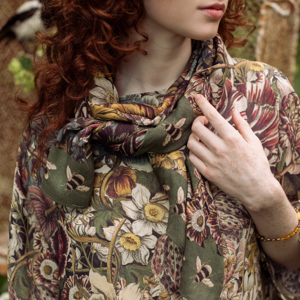 
                  
                    Model wearing soft viscose scarf featuring 1700s March botanical etchings and bumblebee trim from vintage seed catalogue – Market of Stars.
                  
                
