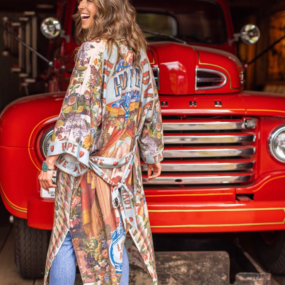 
                  
                    Model wearing romantic full-length kimono featuring joyful 1854 floral art, heart-in-hand symbol, and handwritten messages of love – Market of Stars
                  
                
