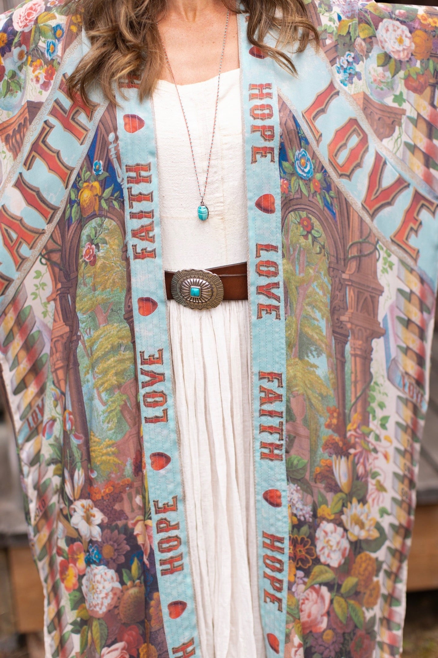 Model wearing romantic full-length kimono featuring joyful 1854 floral art, heart-in-hand symbol, and handwritten messages of love – Market of Stars