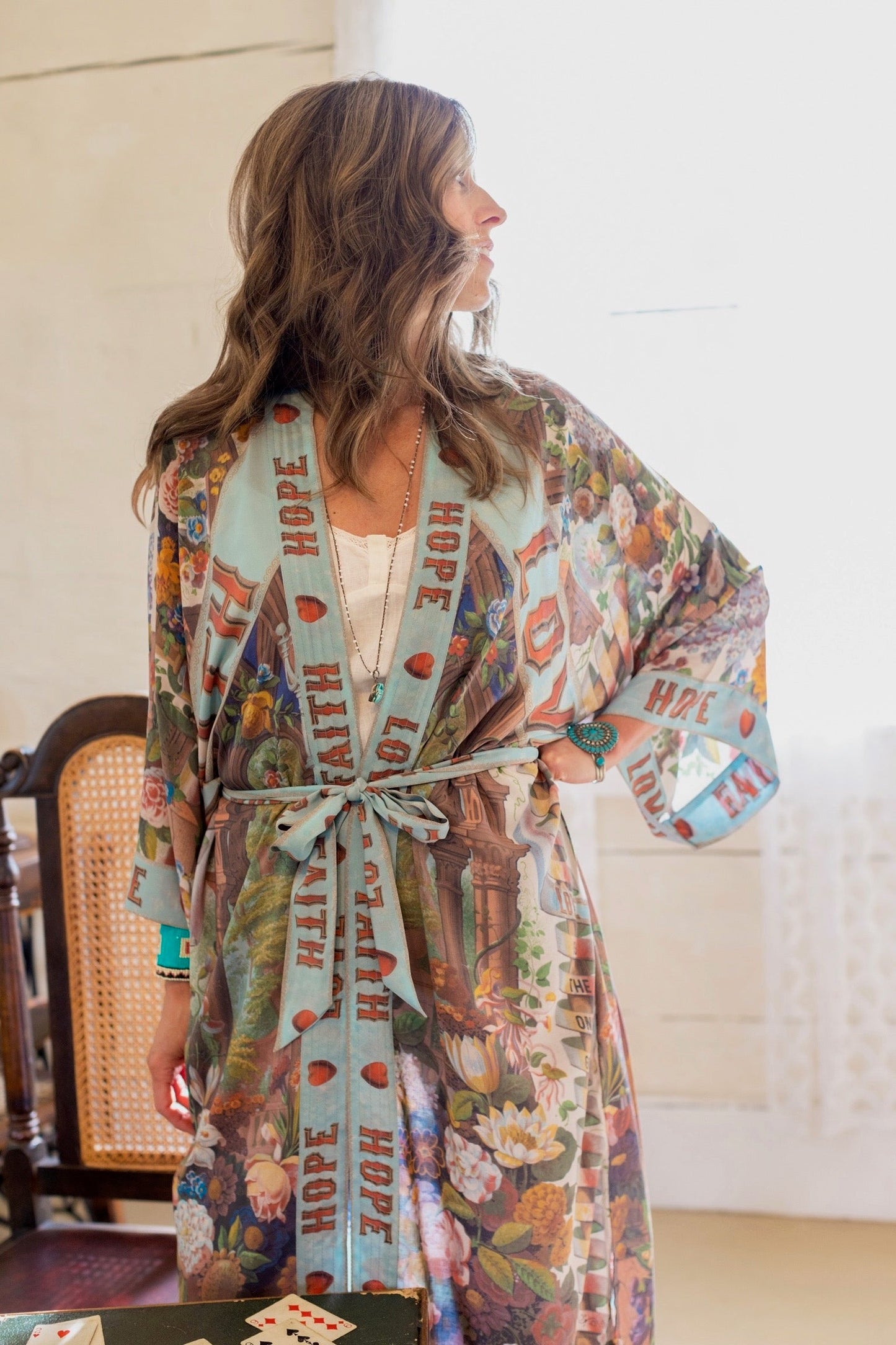 Model wearing romantic full-length kimono featuring joyful 1854 floral art, heart-in-hand symbol, and handwritten messages of love – Market of Stars