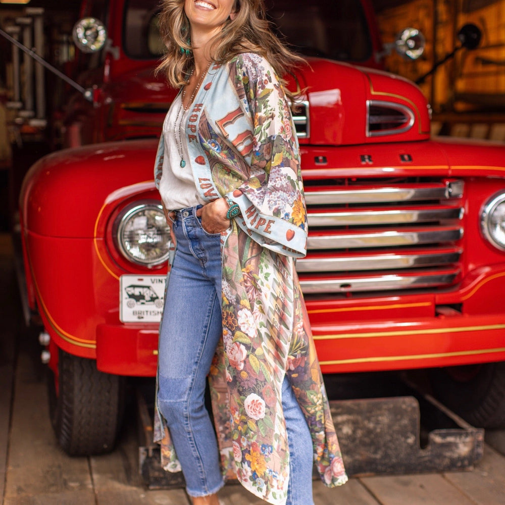
                  
                    Model wearing romantic full-length kimono featuring joyful 1854 floral art, heart-in-hand symbol, and handwritten messages of love – Market of Stars
                  
                