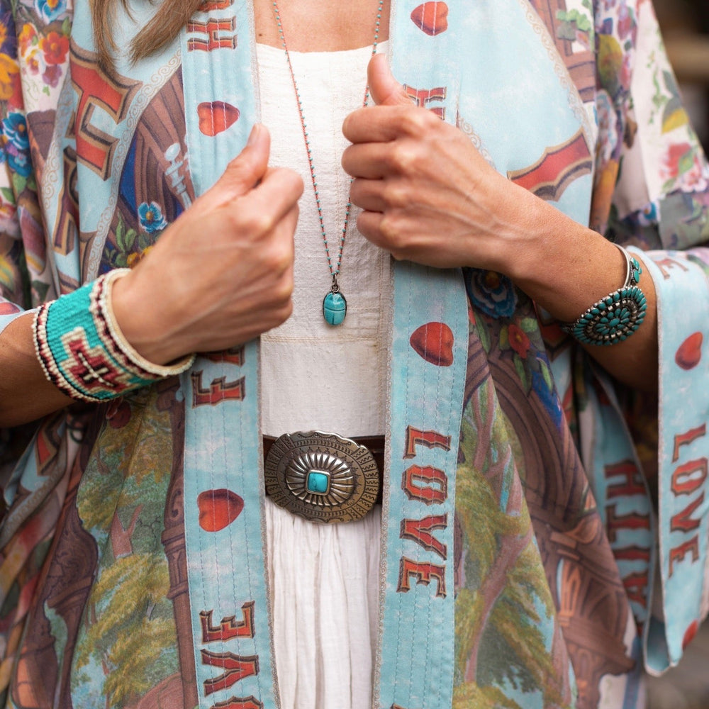 
                  
                    Model wearing romantic full-length kimono featuring joyful 1854 floral art, heart-in-hand symbol, and handwritten messages of love – Market of Stars
                  
                