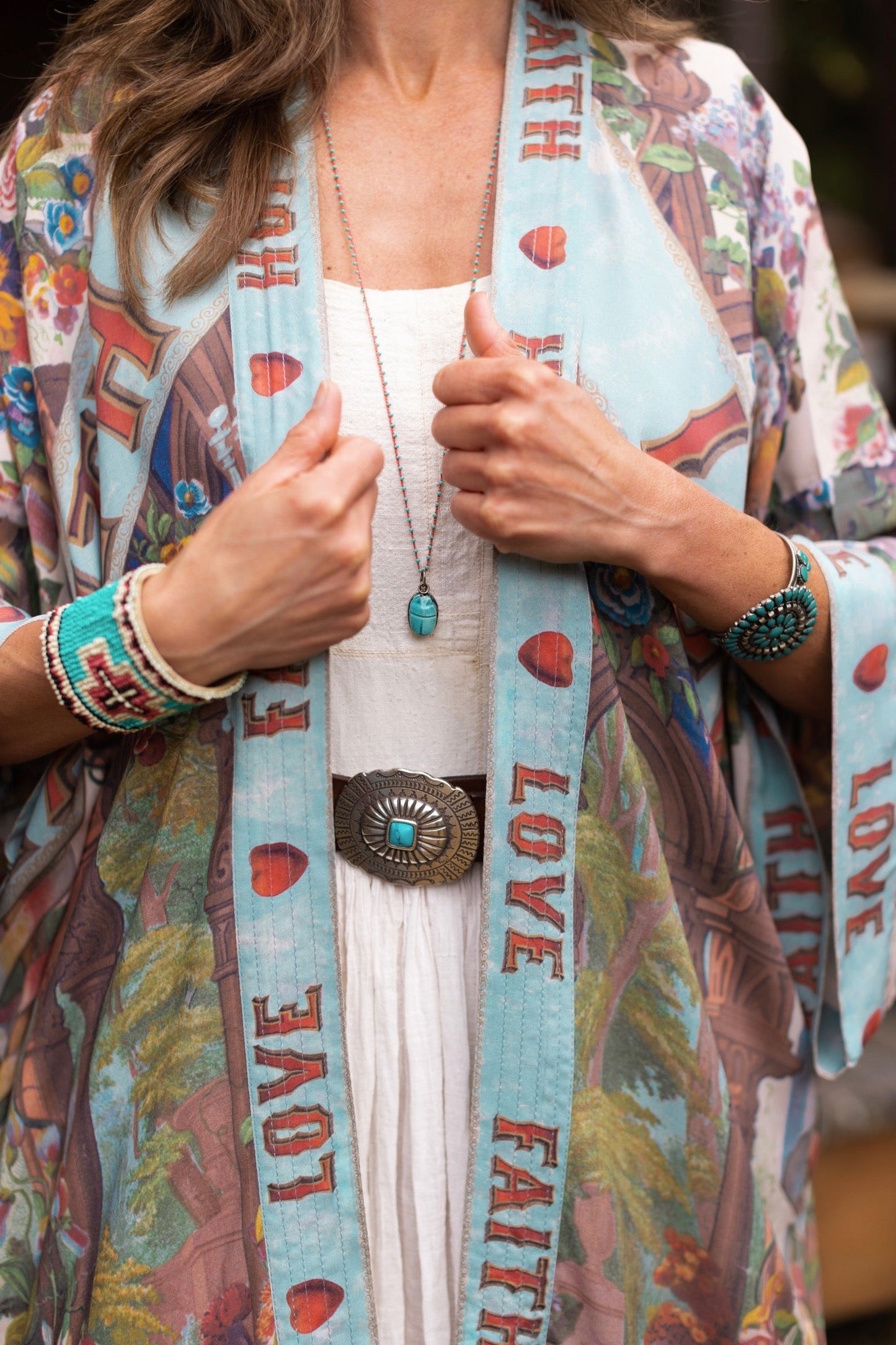 Model wearing romantic full-length kimono featuring joyful 1854 floral art, heart-in-hand symbol, and handwritten messages of love – Market of Stars