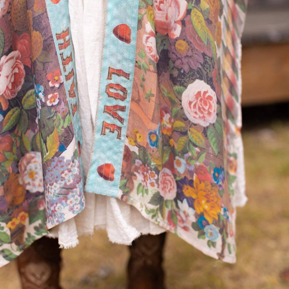 
                  
                    Model wearing romantic full-length kimono featuring joyful 1854 floral art, heart-in-hand symbol, and handwritten messages of love – Market of Stars
                  
                