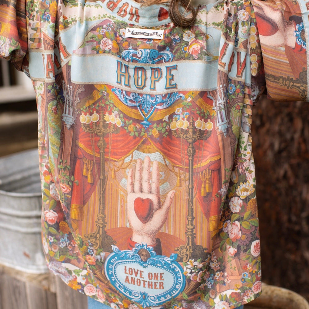 
                  
                    Model in cropped kimono featuring joyful 1854 floral art, heart-in-hand symbol, and handwritten love notes – Market of Stars.
                  
                