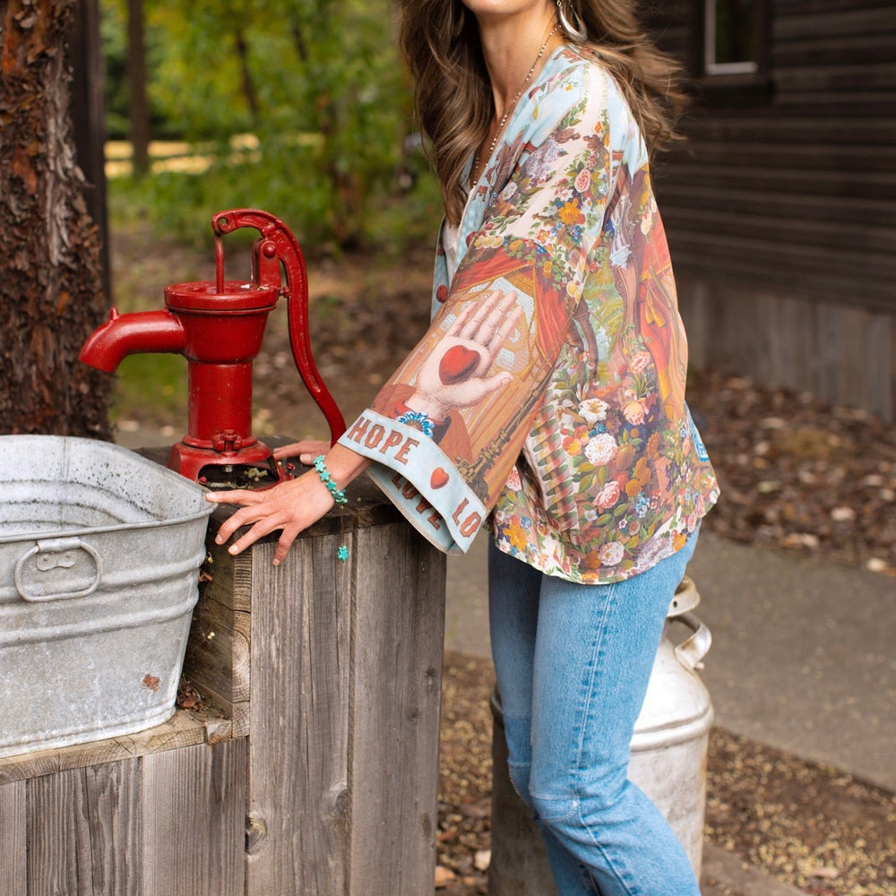 
                  
                    Model in cropped kimono featuring joyful 1854 floral art, heart-in-hand symbol, and handwritten love notes – Market of Stars.
                  
                