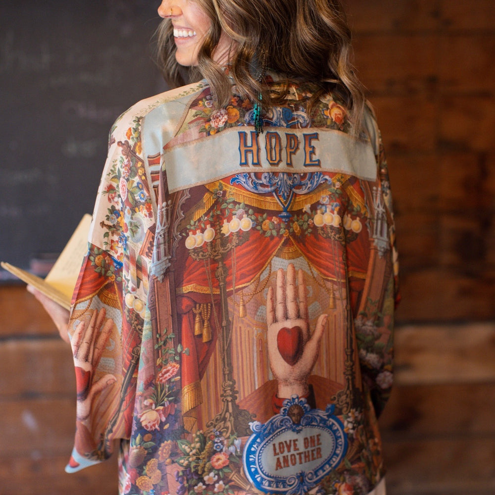 
                  
                    Model in cropped kimono featuring joyful 1854 floral art, heart-in-hand symbol, and handwritten love notes – Market of Stars.
                  
                