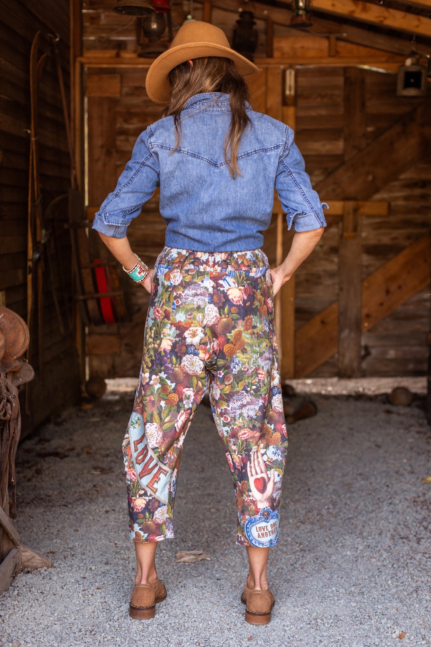 Model wearing linen blend artist pants with 1854 floral art, heart-in-hand symbol, and “Love one another” handwritten script – Market of Stars.