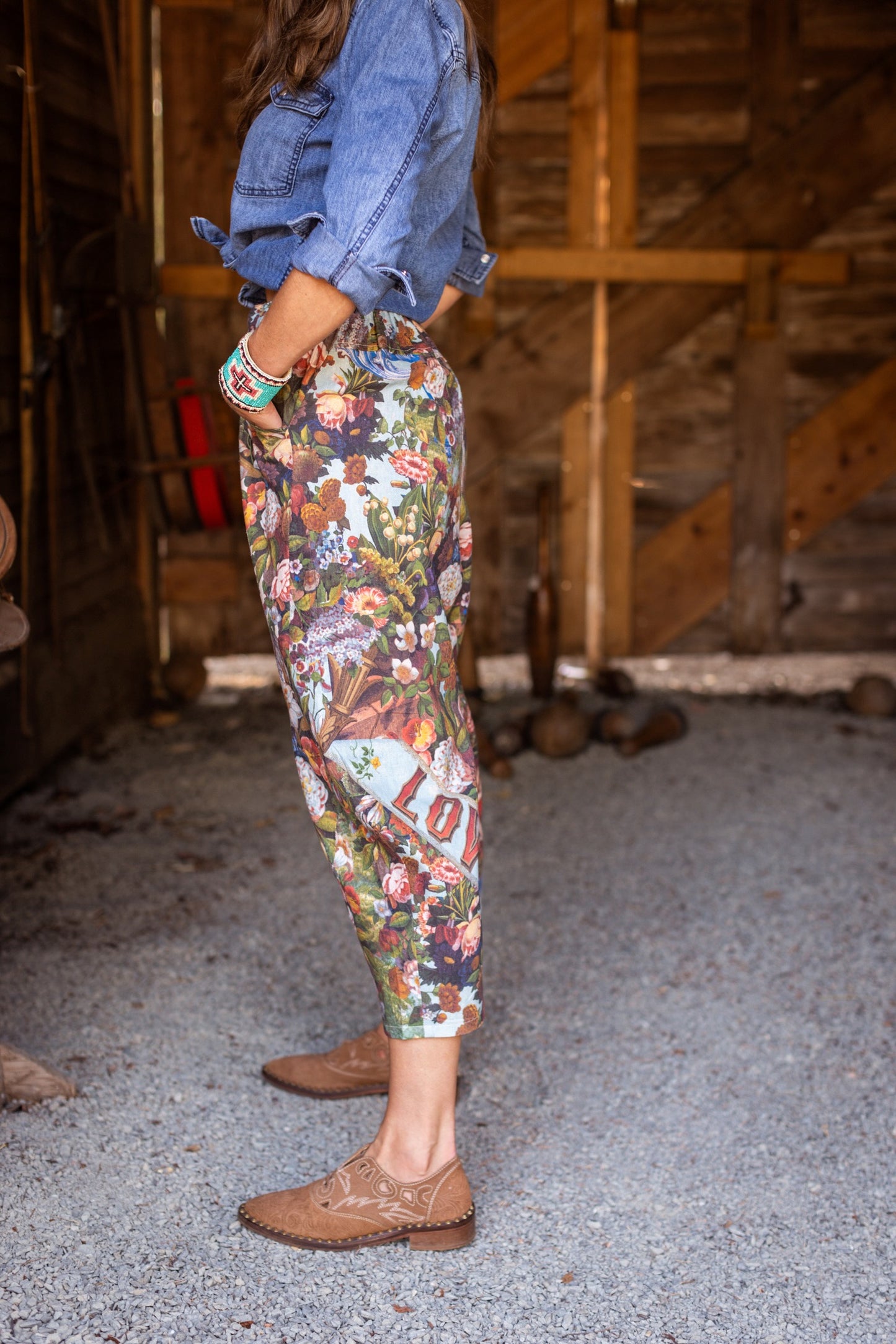 Model wearing linen blend artist pants with 1854 floral art, heart-in-hand symbol, and “Love one another” handwritten script – Market of Stars.