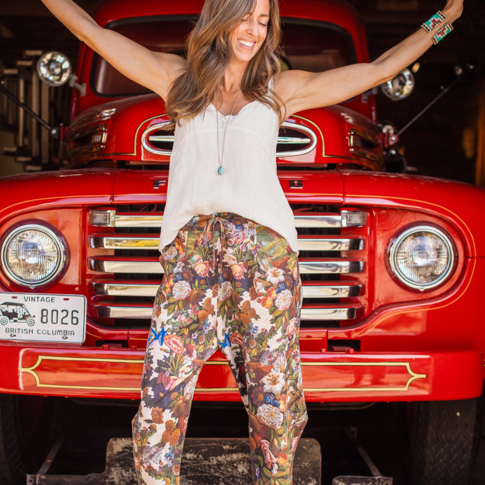 
                  
                    Model wearing linen blend artist pants with 1854 floral art, heart-in-hand symbol, and “Love one another” handwritten script – Market of Stars.
                  
                