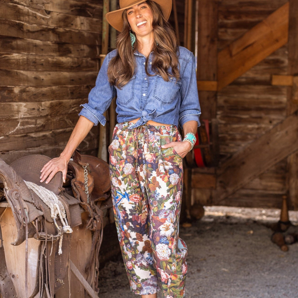 
                  
                    Model wearing linen blend artist pants with 1854 floral art, heart-in-hand symbol, and “Love one another” handwritten script – Market of Stars.
                  
                
