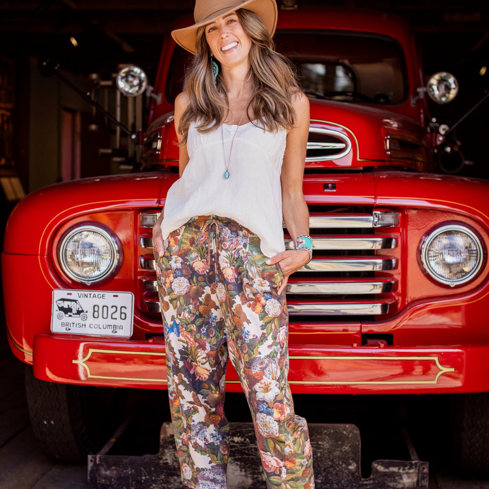 
                  
                    Model wearing linen blend artist pants with 1854 floral art, heart-in-hand symbol, and “Love one another” handwritten script – Market of Stars.
                  
                
