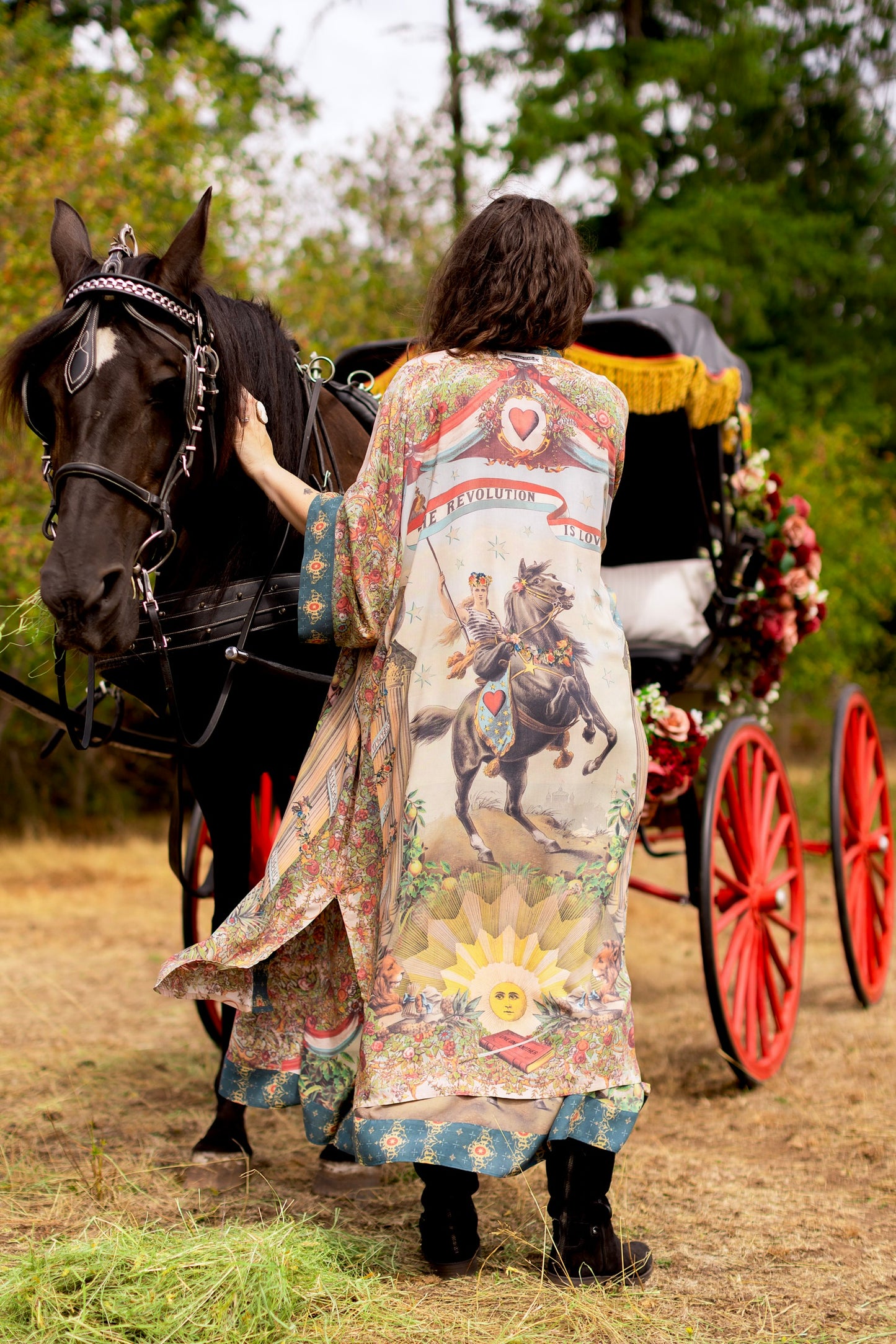 Model wearing a full-length duster ft. a woman astride a rearing horse, soft vintage florals, rosettes and lithographs from the 1800's - Market of Stars