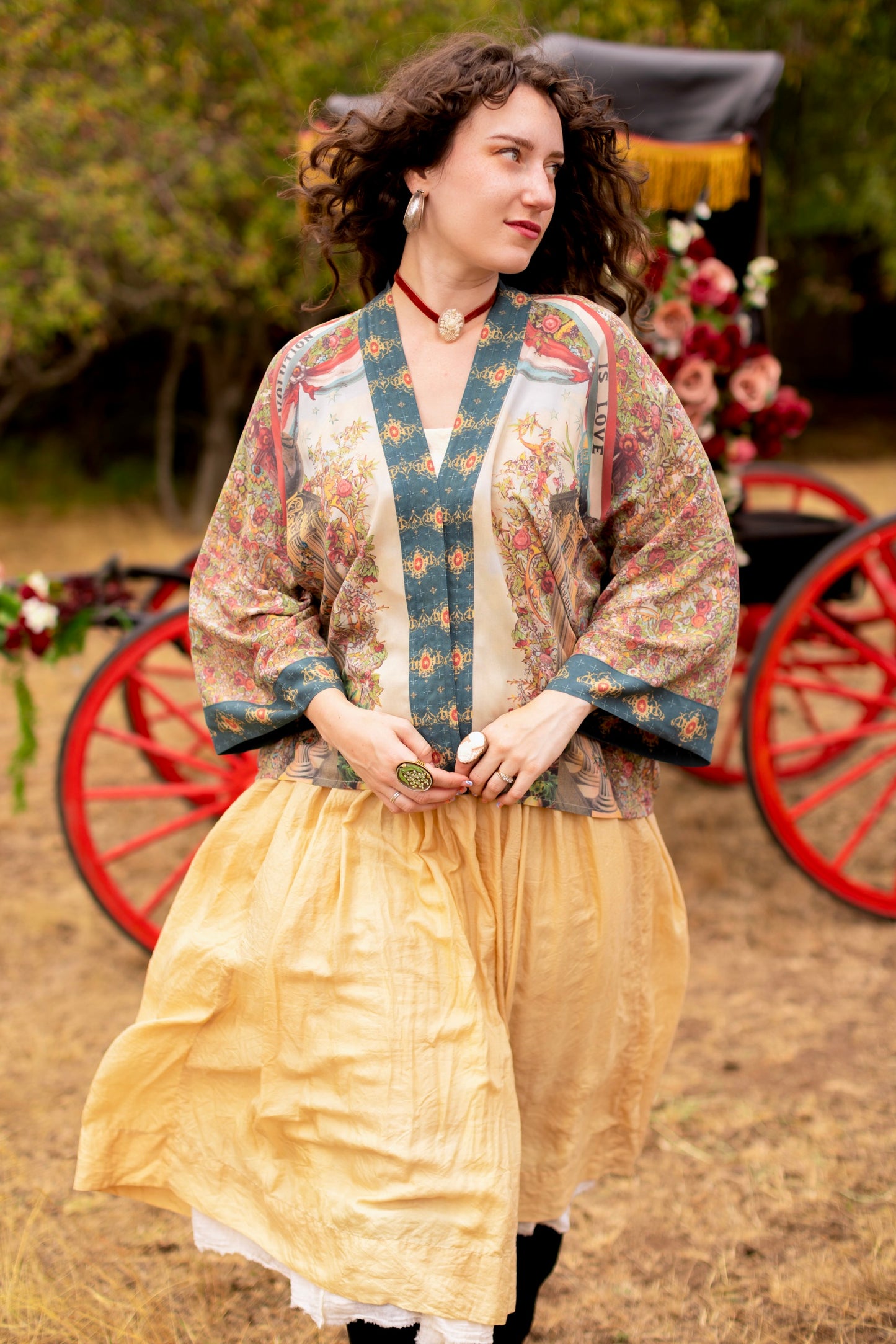 Model wearing cropped length duster ft. a woman astride a rearing horse, soft vintage florals, rosettes and lithographs from the 1800's - Market of Stars
