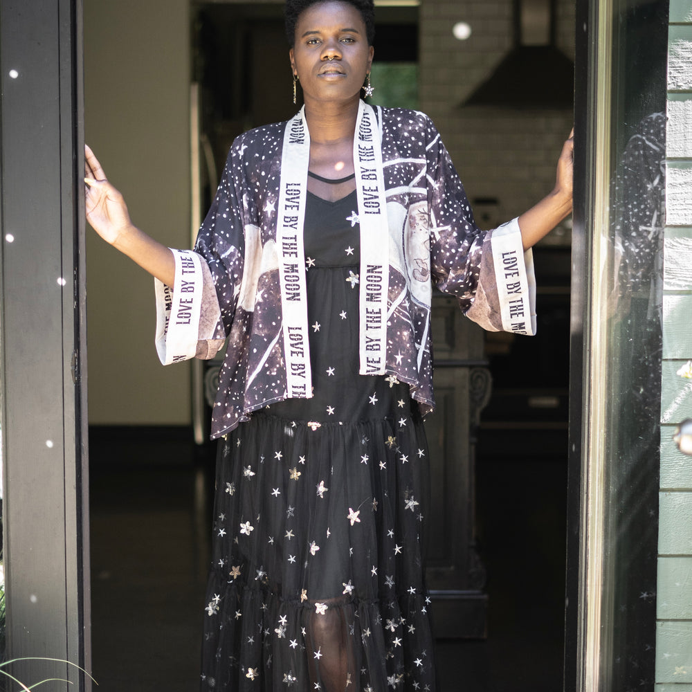 
                  
                    Model wearing Love By The Moon Kimono featuring sepia tones, vintage moon illustration, and retro typography inspired by early 1900s photo props – Market of Stars
                  
                