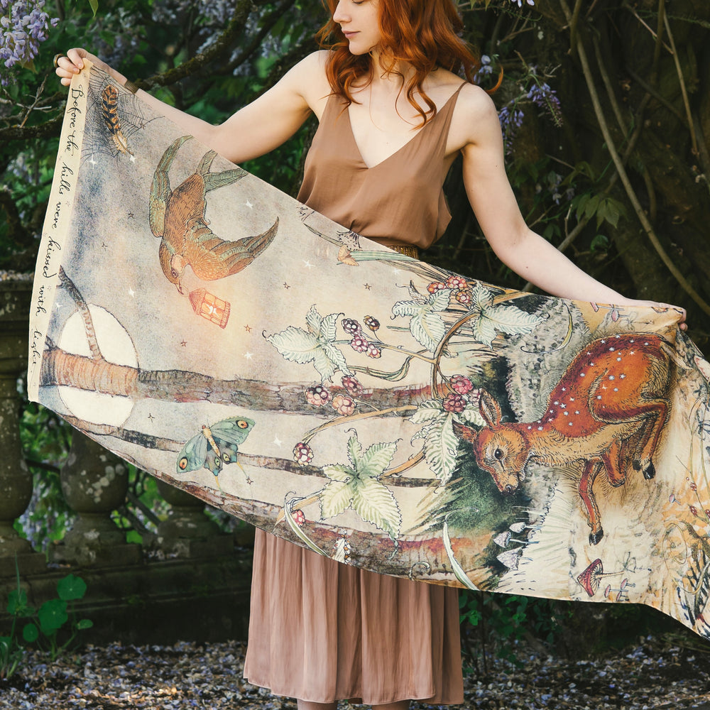 Model wearing an enchanting scarf featuring Charles van Sandwyck's illustrations, crafted from airy bamboo-based viscose with a touch of whimsical magic - Market of Stars