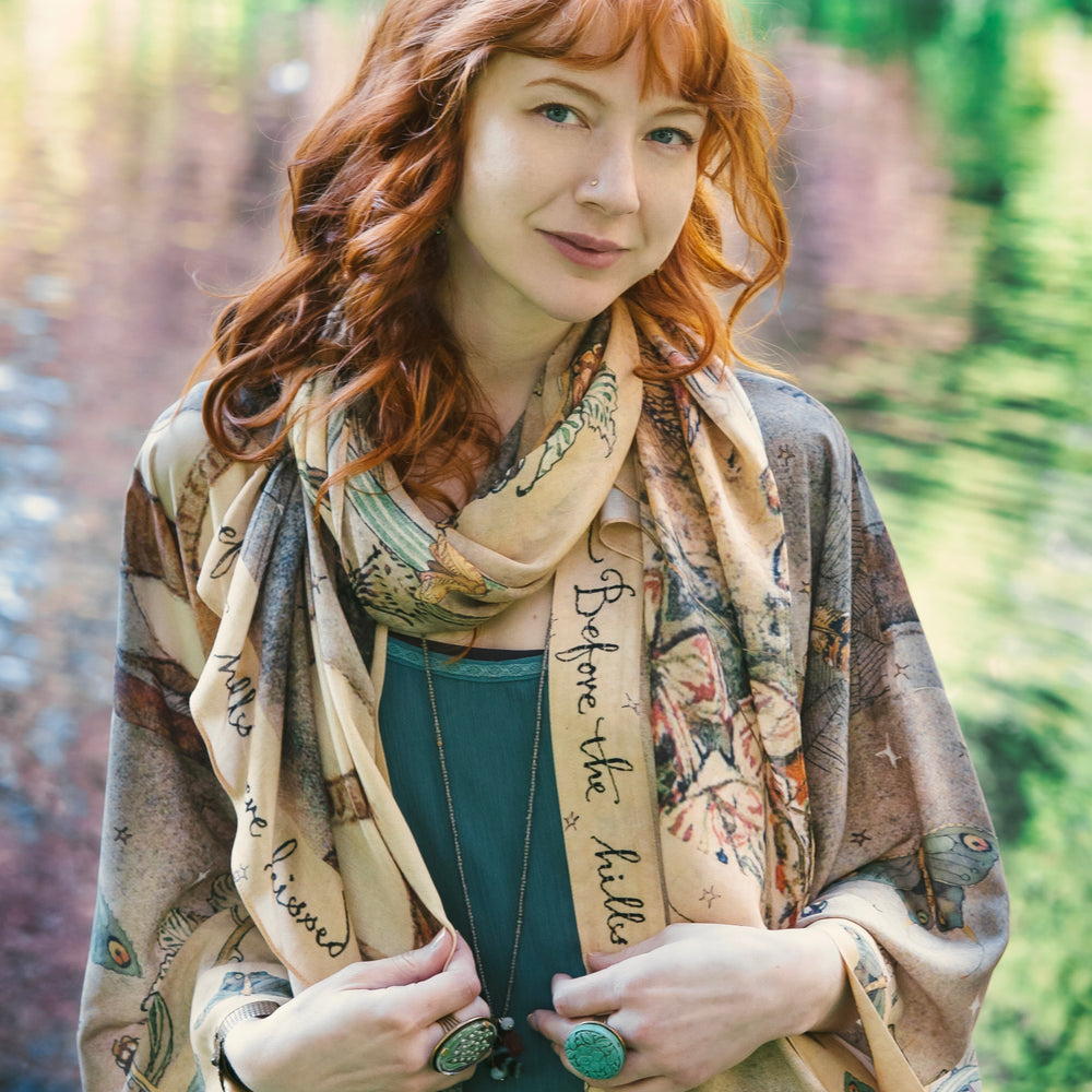 
                  
                    Model wearing an enchanting scarf featuring Charles van Sandwyck's illustrations, crafted from airy bamboo-based viscose with a touch of whimsical magic - Market of Stars
                  
                