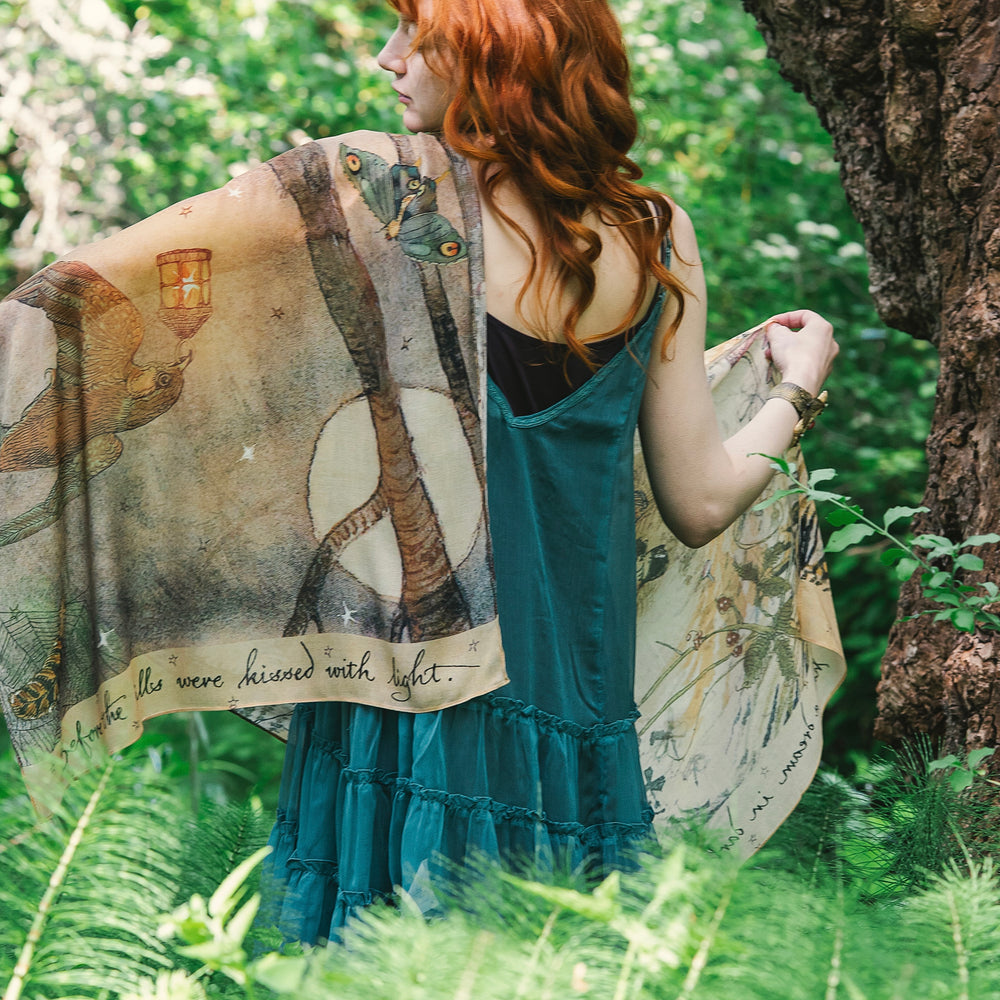 
                  
                    Model wearing an enchanting scarf featuring Charles van Sandwyck's illustrations, crafted from airy bamboo-based viscose with a touch of whimsical magic - Market of Stars
                  
                