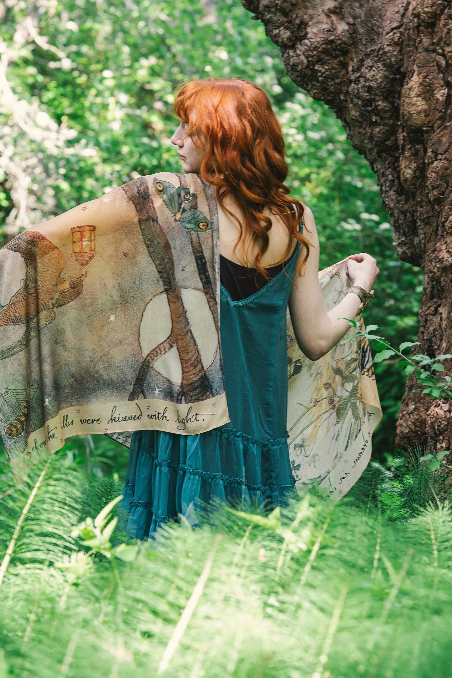 Model wearing an enchanting scarf featuring Charles van Sandwyck's illustrations, crafted from airy bamboo-based viscose with a touch of whimsical magic - Market of Stars