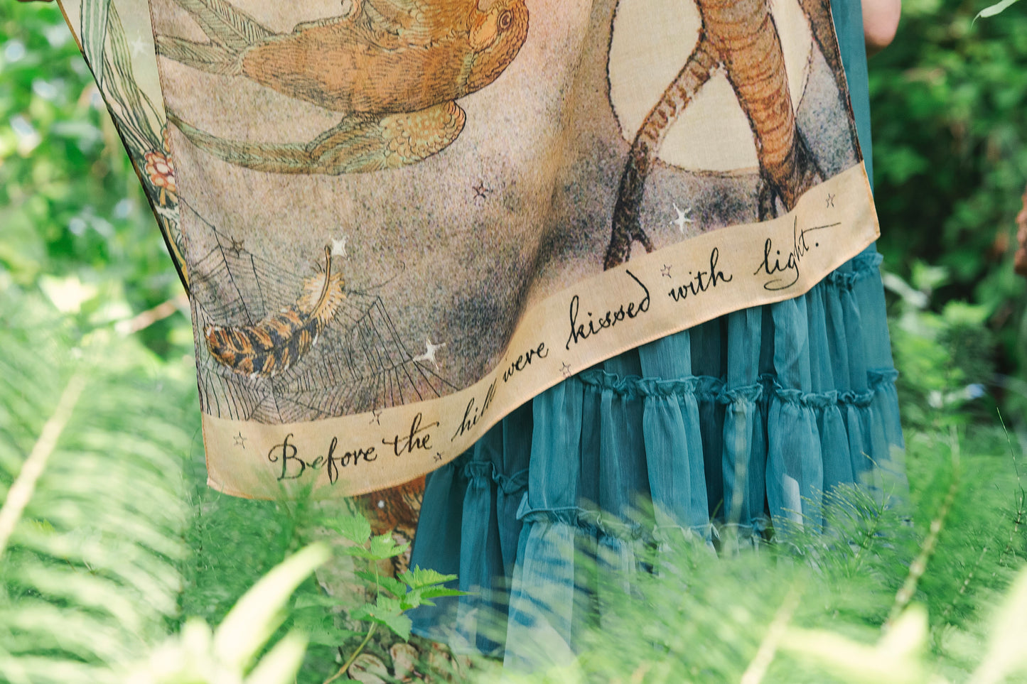 Model wearing an enchanting scarf featuring Charles van Sandwyck's illustrations, crafted from airy bamboo-based viscose with a touch of whimsical magic - Market of Stars