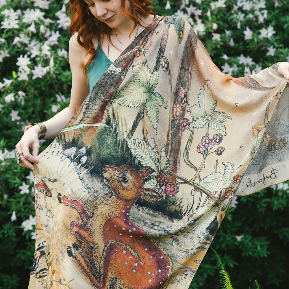 
                  
                    Model wearing an enchanting scarf featuring Charles van Sandwyck's illustrations, crafted from airy bamboo-based viscose with a touch of whimsical magic - Market of Stars
                  
                