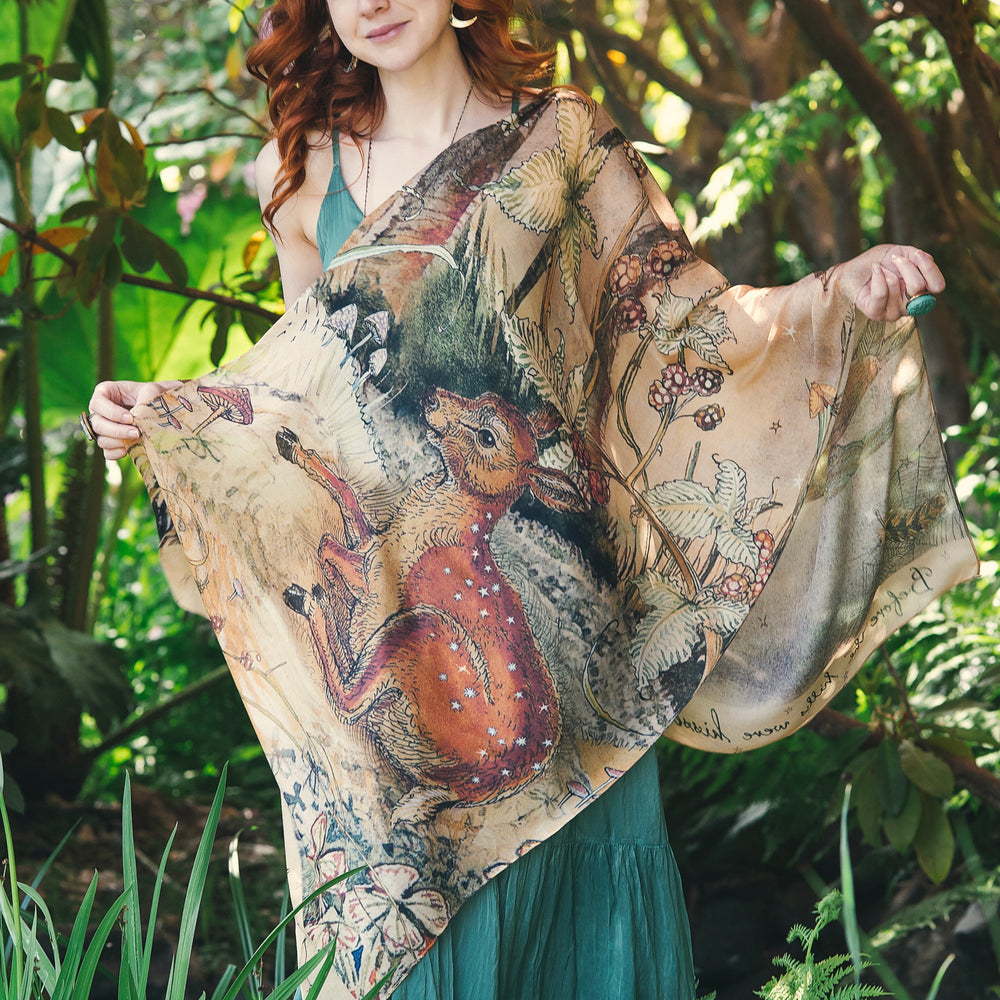 
                  
                    Model wearing an enchanting scarf featuring Charles van Sandwyck's illustrations, crafted from airy bamboo-based viscose with a touch of whimsical magic - Market of Stars
                  
                