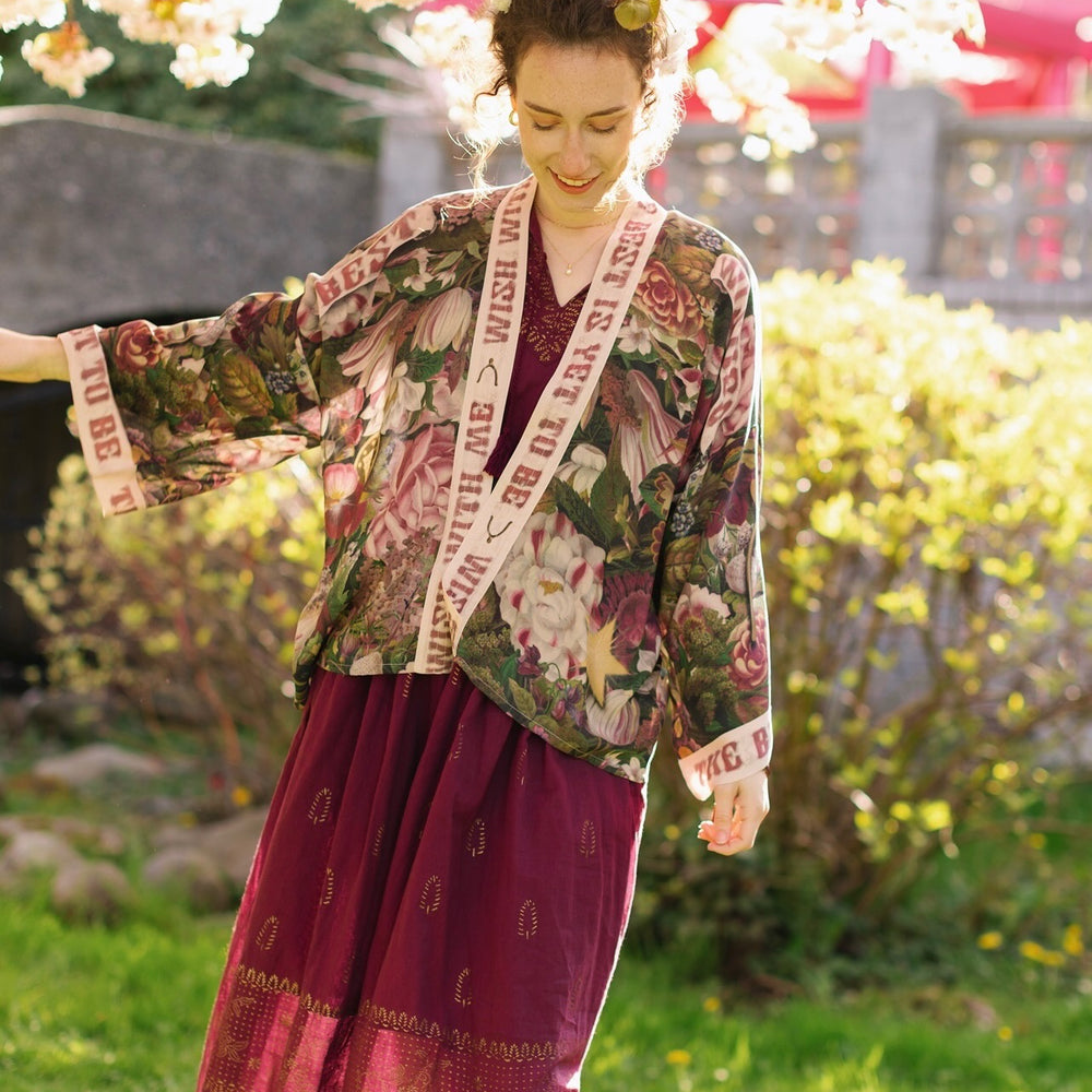 
                  
                    Model wearing cropped kimono featuring gold wishbone–vintage coin–evening star–dandelion–and spring floral collage with “Make a wish” banner – Market of Stars
                  
                