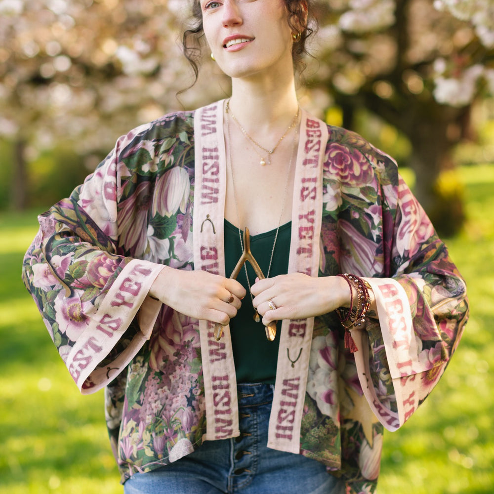 
                  
                    Model wearing cropped kimono featuring gold wishbone–vintage coin–evening star–dandelion–and spring floral collage with “Make a wish” banner – Market of Stars
                  
                