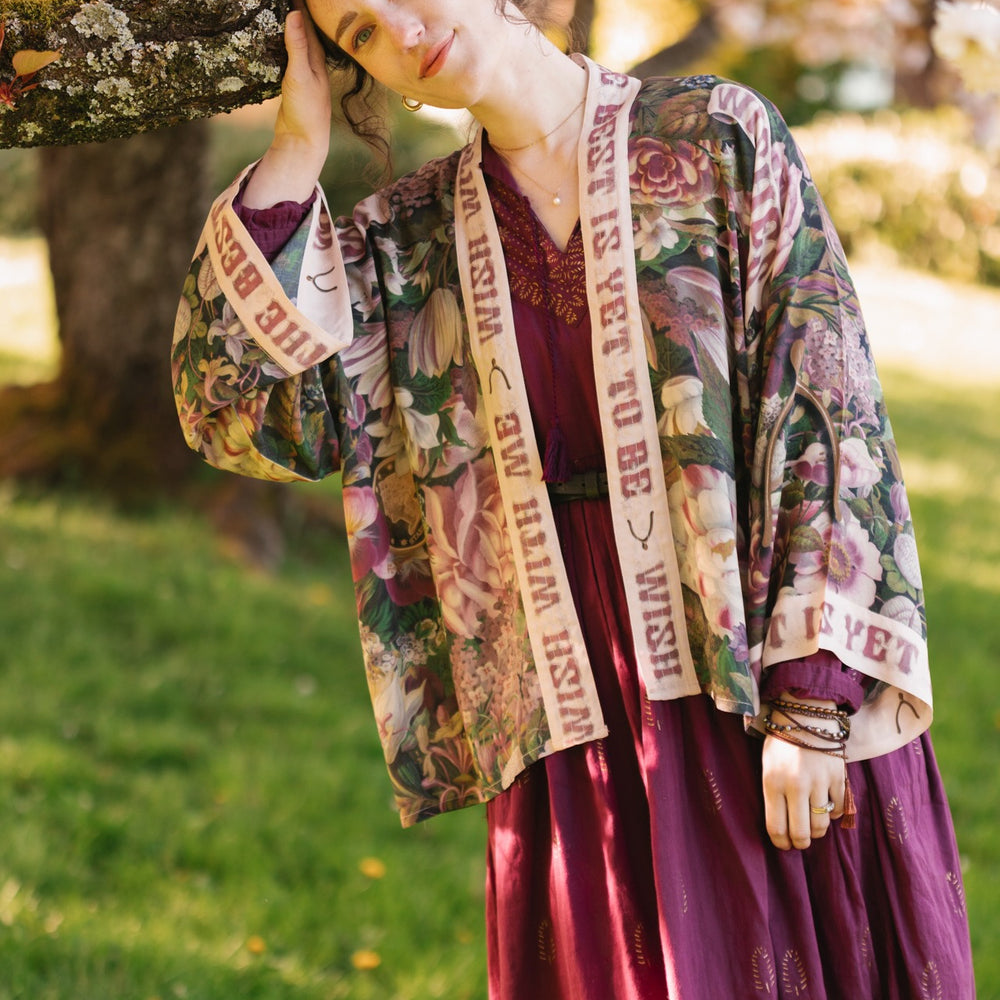 
                  
                    Model wearing cropped kimono featuring gold wishbone–vintage coin–evening star–dandelion–and spring floral collage with “Make a wish” banner – Market of Stars
                  
                