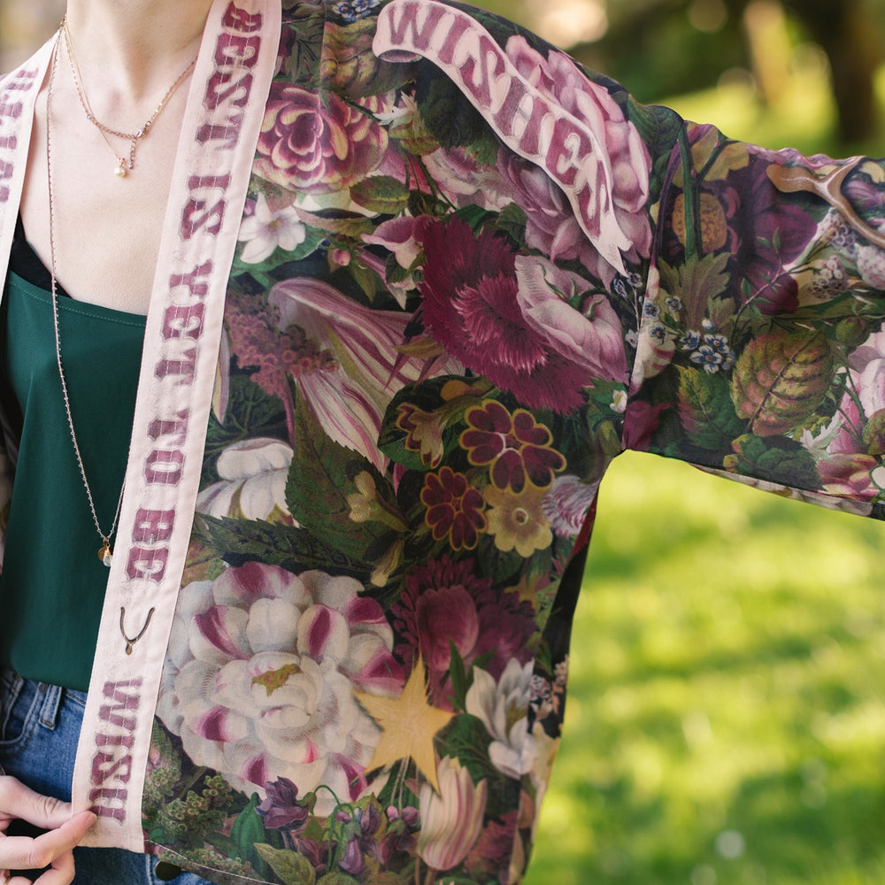 
                  
                    Model wearing cropped kimono featuring gold wishbone–vintage coin–evening star–dandelion–and spring floral collage with “Make a wish” banner – Market of Stars
                  
                