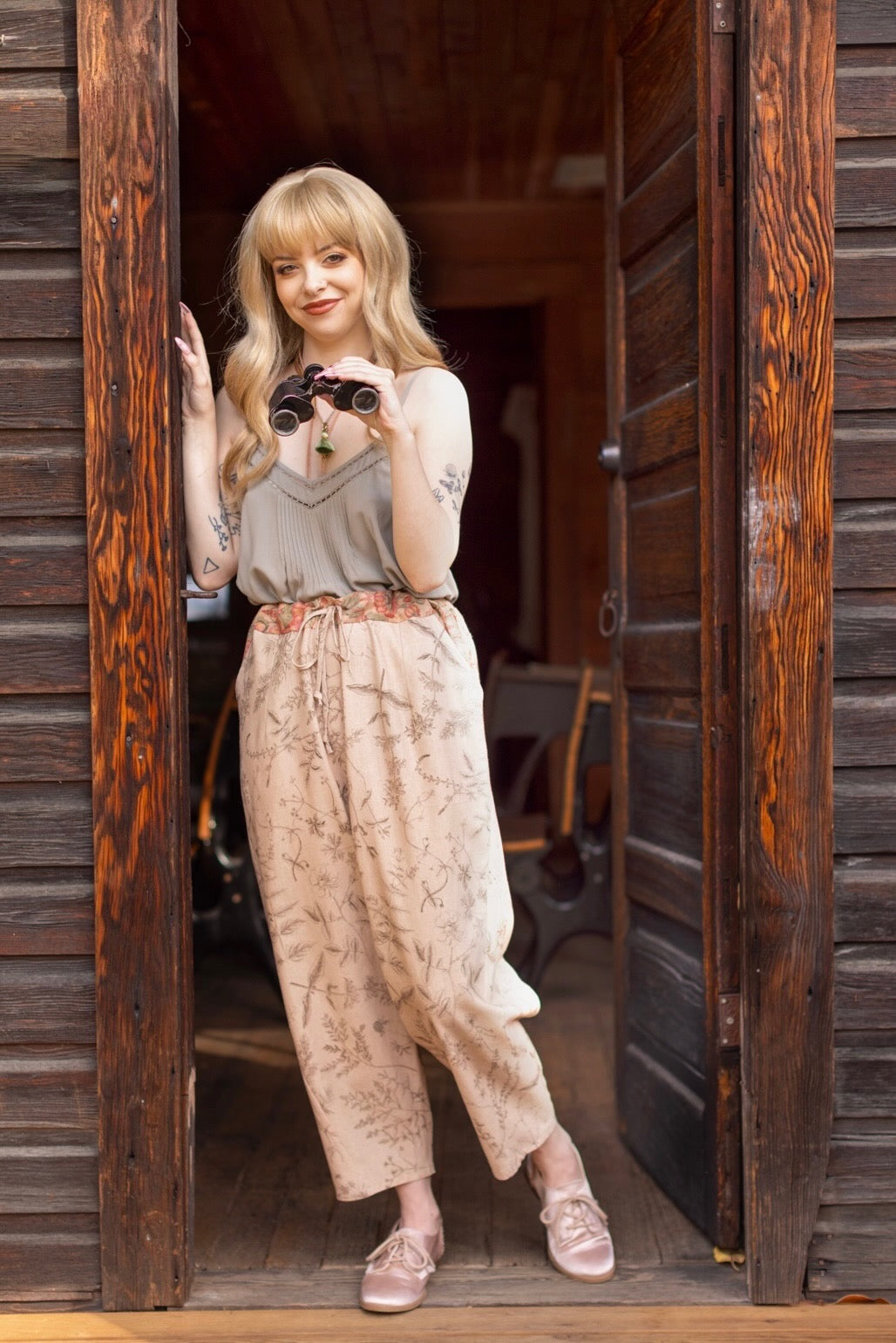 Model wearing artist pants in oat featuring reimagined vintage 1846 map of a woman’s heart with playful updated place names – Market of Stars